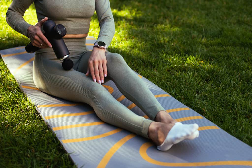 Deep Tissue Massage Gun in use on leg outside