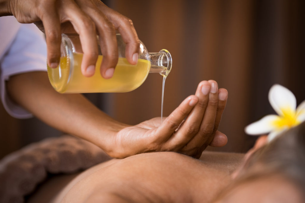 therapist using massage oil